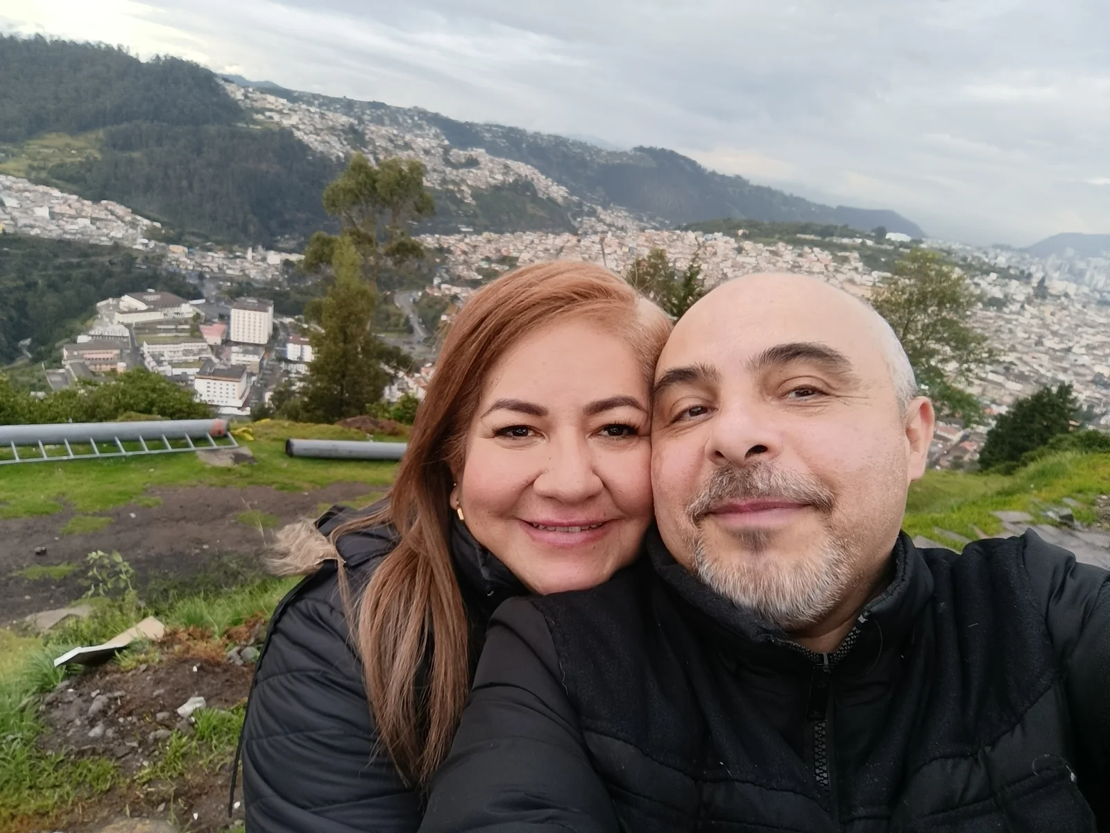 Frank y Nel con la vista de Quito y las montañas al fondo
